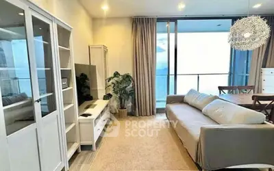 Spacious living room with modern decor and stunning ocean view balcony.