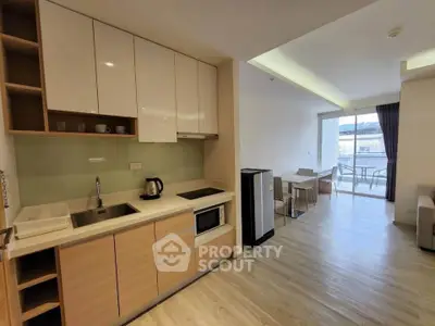 Modern open-plan kitchen and living area with balcony view
