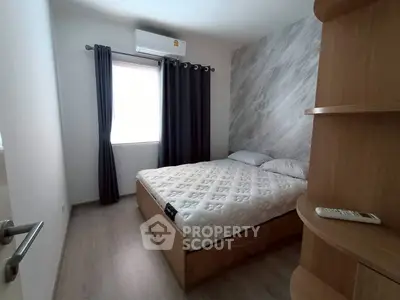 Cozy bedroom with modern decor and natural light, perfect for relaxation.