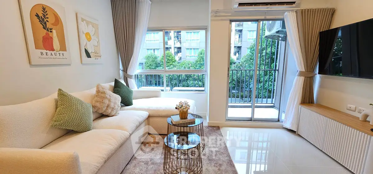 Modern living room with large windows and balcony access, featuring stylish decor and natural light.