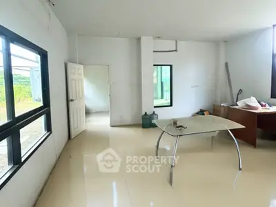 Spacious interior room with large windows and modern table, ideal for office or living space.