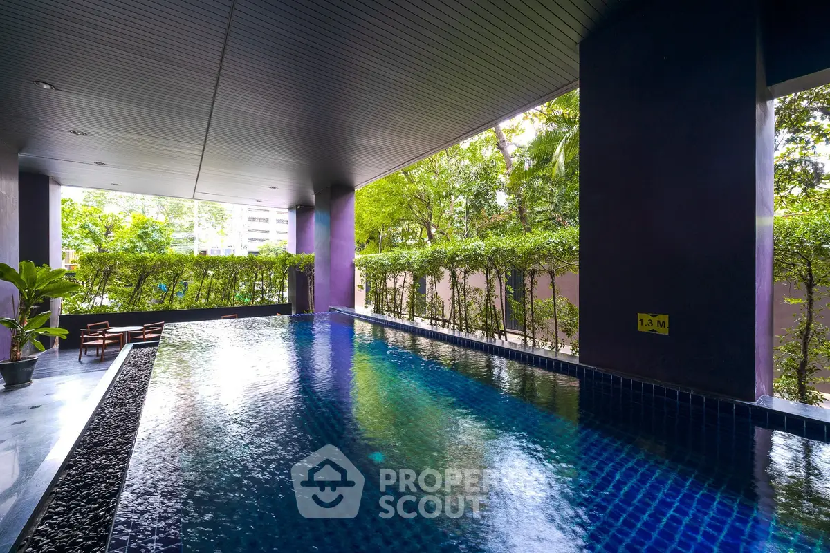 Luxurious indoor pool with lush greenery and modern design, perfect for relaxation and leisure.