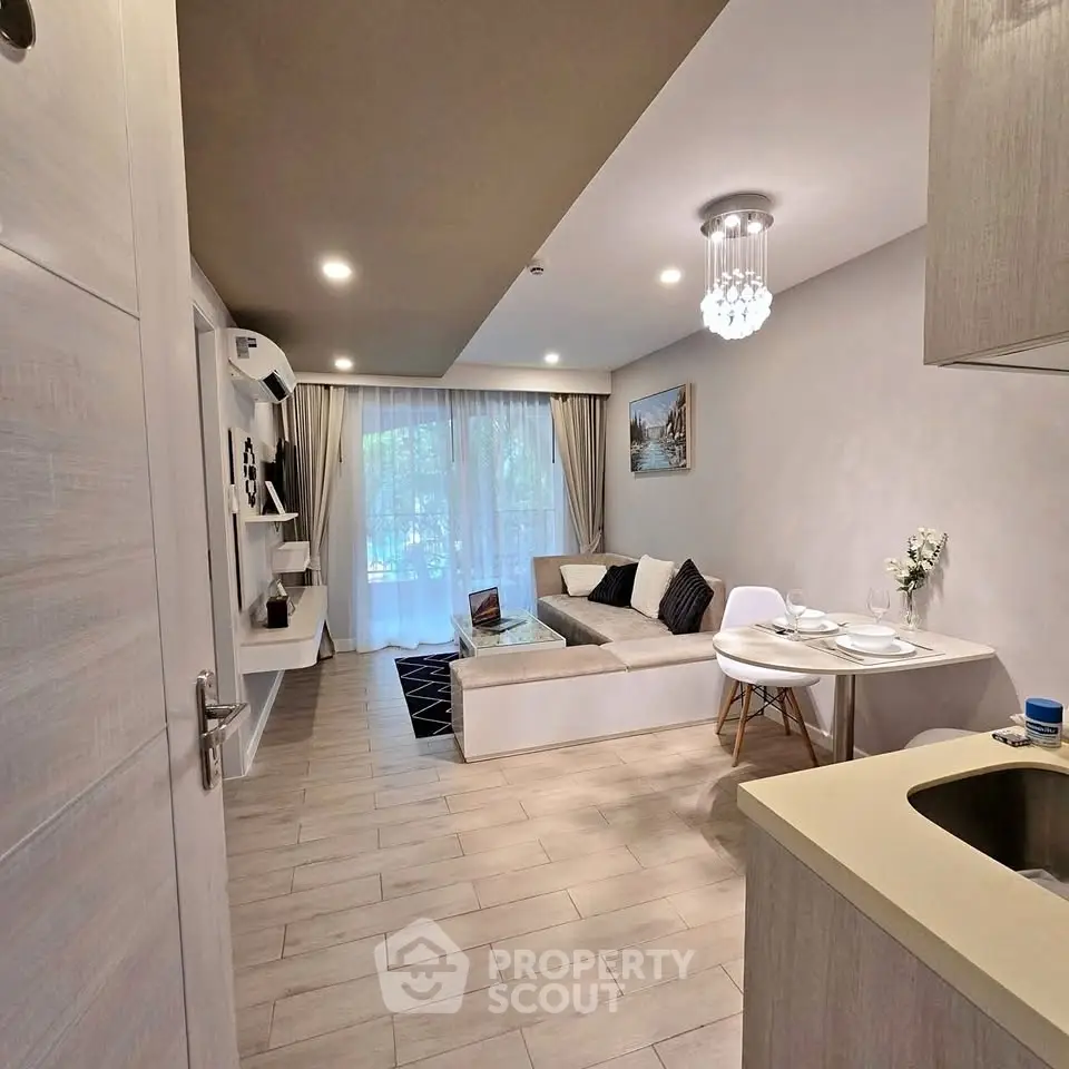 Modern living room with cozy seating and elegant decor, featuring natural light and stylish furnishings.