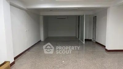 Spacious empty room with polished floors and white walls, ideal for customization in a modern property.