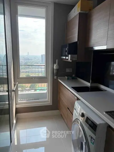 Modern kitchen with city view, featuring sleek appliances and ample natural light.