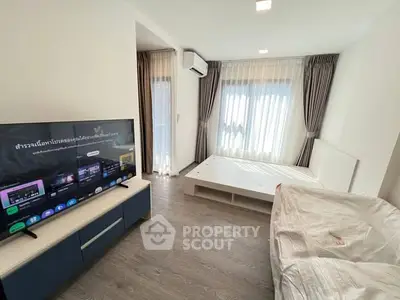 Modern bedroom with sleek TV setup and natural light
