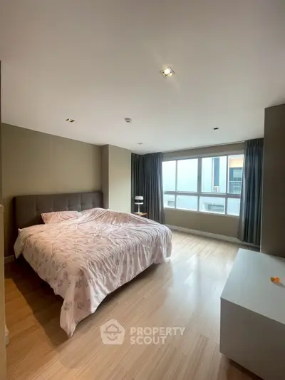 Spacious bedroom with large window and modern decor