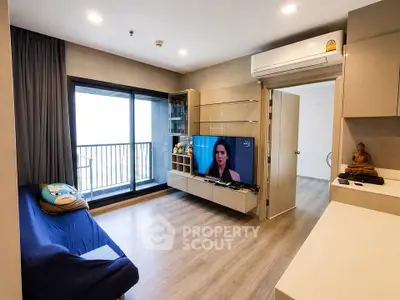 Modern living room with balcony, sleek TV setup, and stylish decor in a high-rise apartment.
