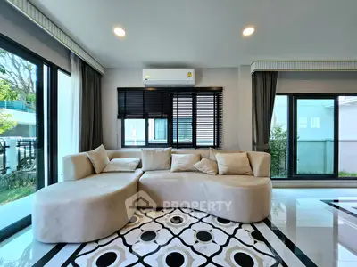 Spacious modern living room with stylish beige sofa and large windows