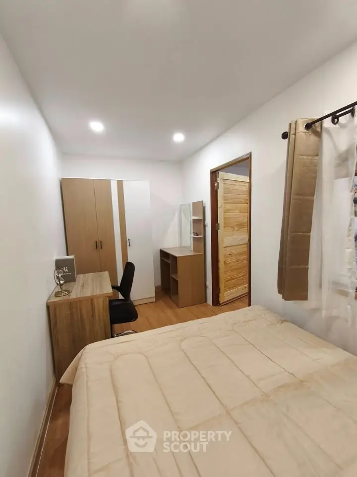 Cozy bedroom with wooden furniture and neutral decor, perfect for relaxation.
