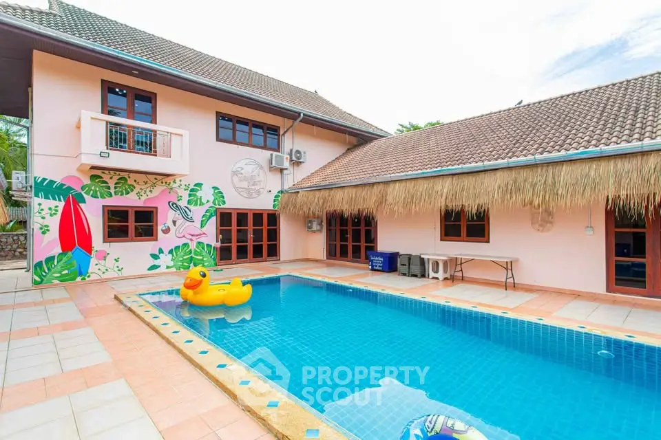 Charming villa with vibrant poolside and tropical mural, perfect for family retreats.
