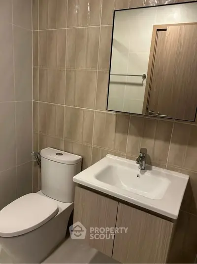 Modern bathroom with sleek fixtures and neutral tile design, perfect for a contemporary home.