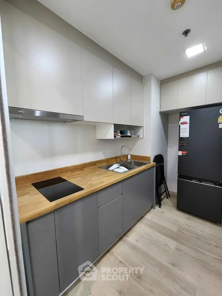 Modern kitchen with sleek cabinets and built-in appliances in a compact layout.