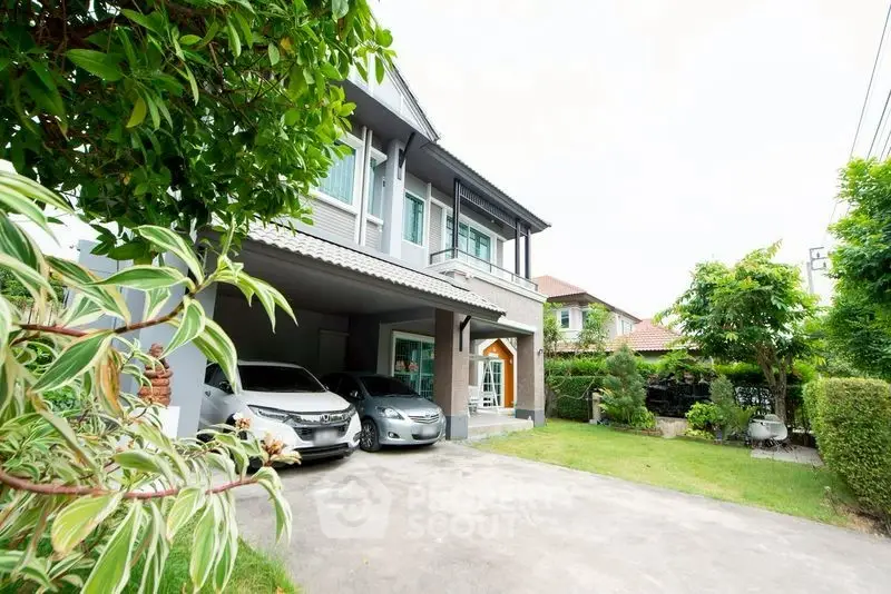 Spacious modern house with lush garden and driveway in a serene neighborhood.