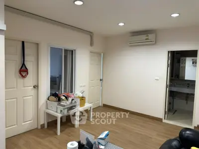 Spacious living area with modern air conditioning and wooden flooring