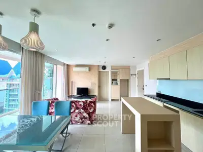 Spacious modern living room with open kitchen and stylish decor in a high-rise apartment.