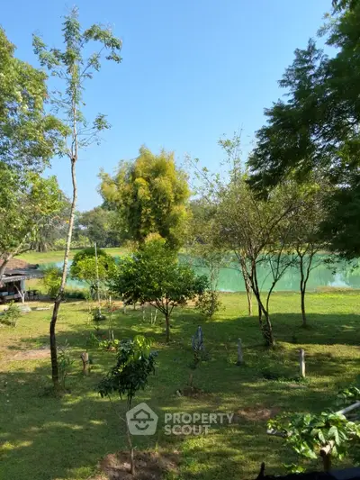 Scenic garden view with lush greenery and tranquil lake backdrop