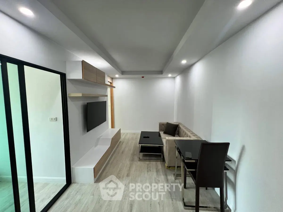 Modern living room with sleek design, featuring a wall-mounted TV and stylish furniture in a bright, minimalist space.