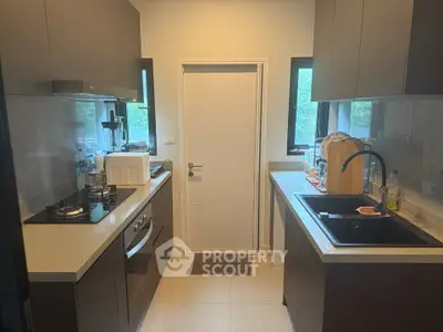 Modern kitchen with sleek cabinetry and gas stove in cozy apartment.
