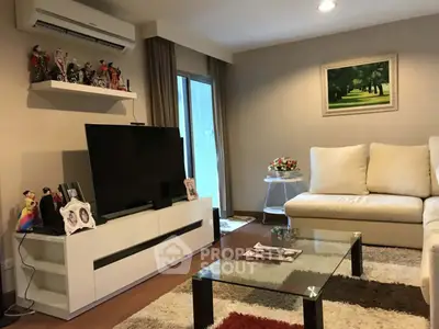 Stylish living room with modern decor and large TV, perfect for relaxation.
