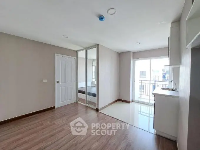 Modern apartment interior with wooden flooring and balcony access