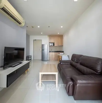 Modern living room with sleek furniture and open kitchen layout in a stylish apartment.