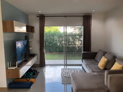 Modern living room with stylish furniture and garden view, perfect for relaxation and entertainment.