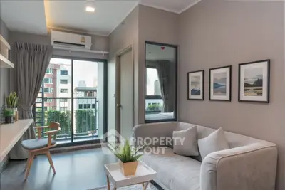 Modern living room with balcony view, stylish decor, and natural light in urban apartment.