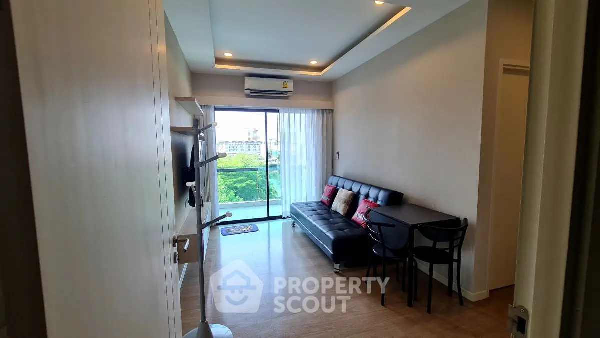 Modern living room with sleek furniture and large window offering a scenic view.