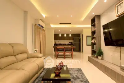 Spacious modern living room with open kitchen and elegant lighting