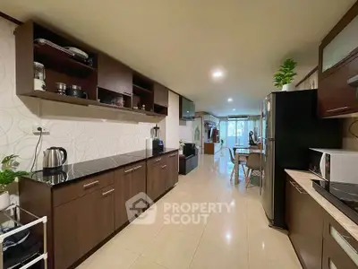 Spacious kitchen with modern appliances and open layout leading to dining area.