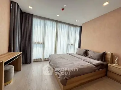 Spacious modern bedroom with large windows and elegant furnishings