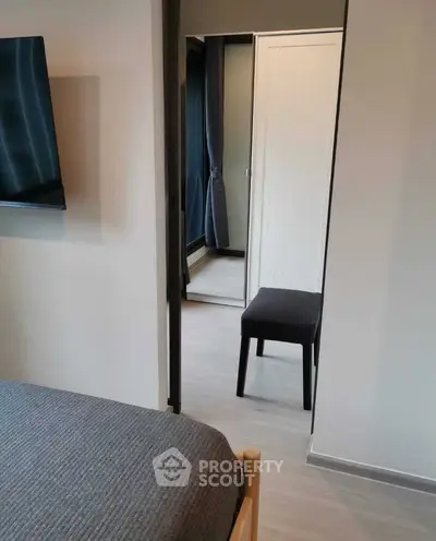 Modern bedroom with sleek furniture and stylish decor, featuring a wall-mounted TV and a cozy atmosphere.