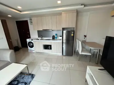 Modern open-layout kitchen with sleek appliances and dining area in a stylish apartment.