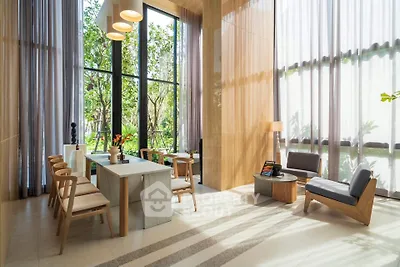 Luxurious modern living room with high ceilings and large windows overlooking a lush garden.