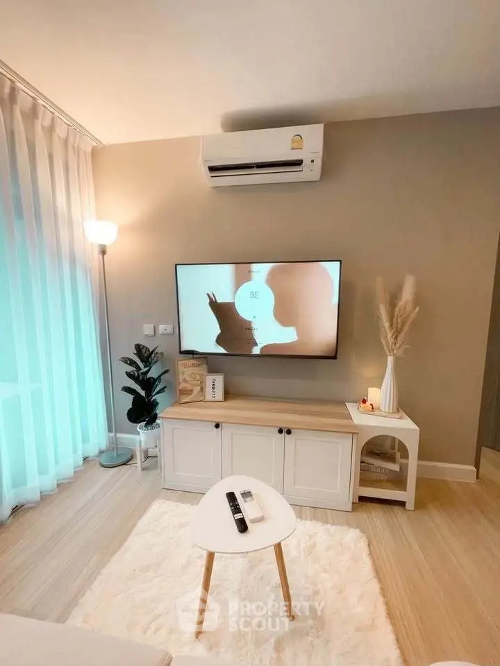 Modern living room with stylish decor, featuring a wall-mounted TV, air conditioning, and cozy lighting.