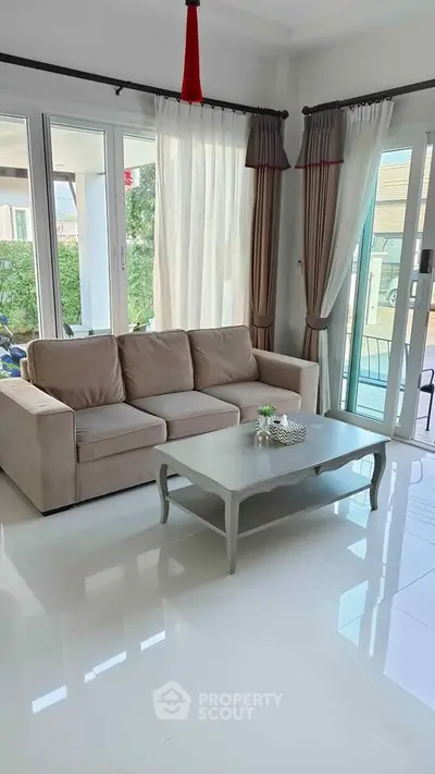 Bright and modern living room with large windows and elegant decor, perfect for relaxation and entertaining.