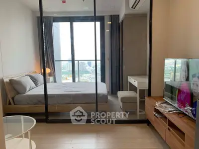 Modern bedroom with glass partition and city view, featuring sleek furniture and a cozy ambiance.
