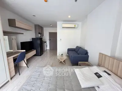 Modern studio apartment with sleek furnishings and open layout, featuring a cozy living area and compact kitchen.