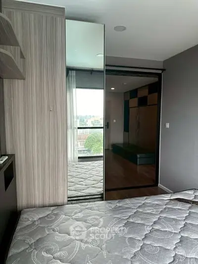 Modern bedroom with mirrored closet and city view