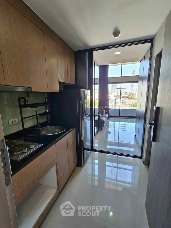 Modern kitchen with sleek design and city view, featuring built-in appliances and ample natural light.