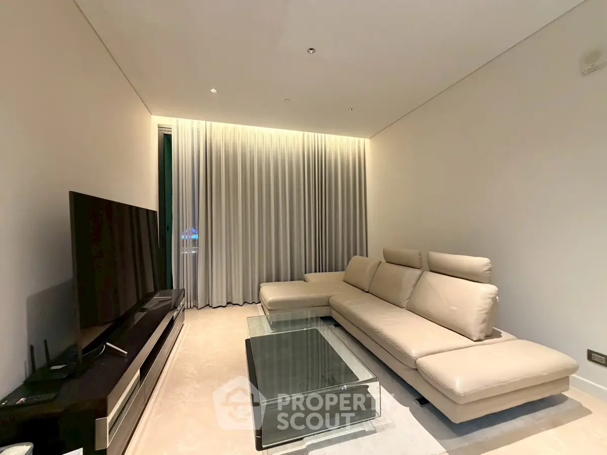 Luxurious modern living room with sleek leather sofa and glass coffee table, perfect for relaxation.