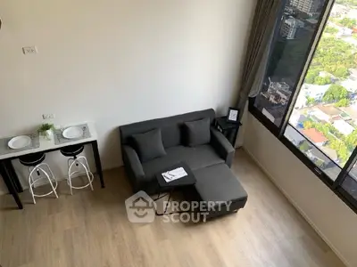Modern living room with a cozy sofa and stunning city view from a high-rise apartment.