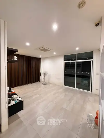 Spacious living room with modern lighting and large windows for natural light.