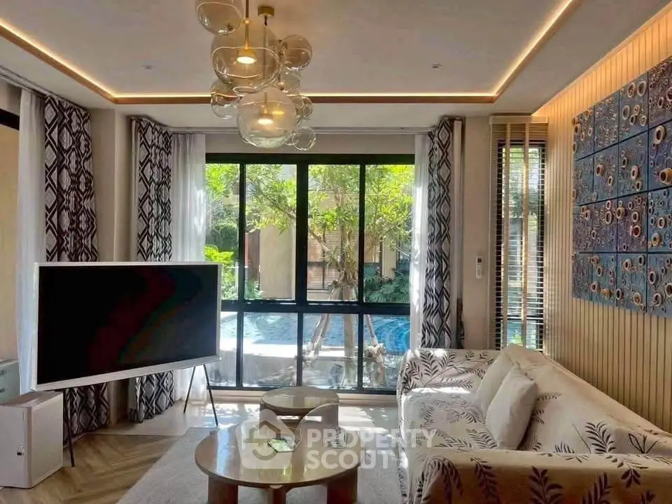 Luxurious living room with pool view, modern decor, and elegant lighting