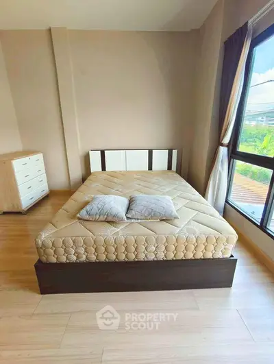 Spacious bedroom with large window and modern furnishings