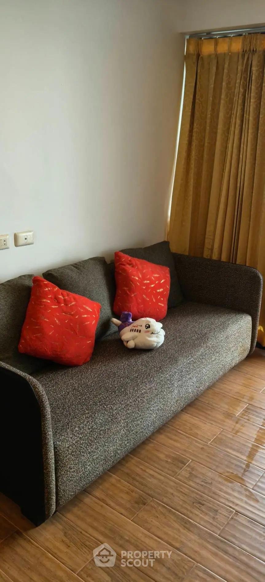 Cozy living room with modern sofa and vibrant red cushions