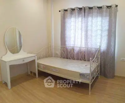Cozy bedroom with daybed and vanity, perfect for relaxation.
