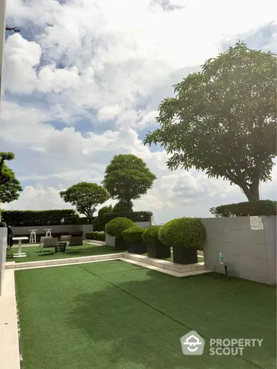 Stunning rooftop garden with lush greenery and seating area under a bright sky.