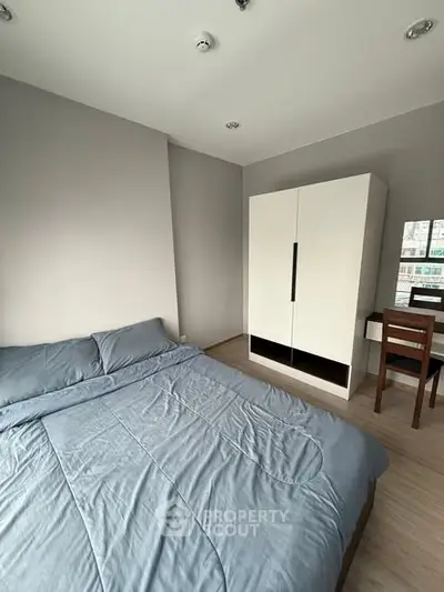 Modern bedroom with sleek wardrobe and cozy bedding in a stylish apartment.